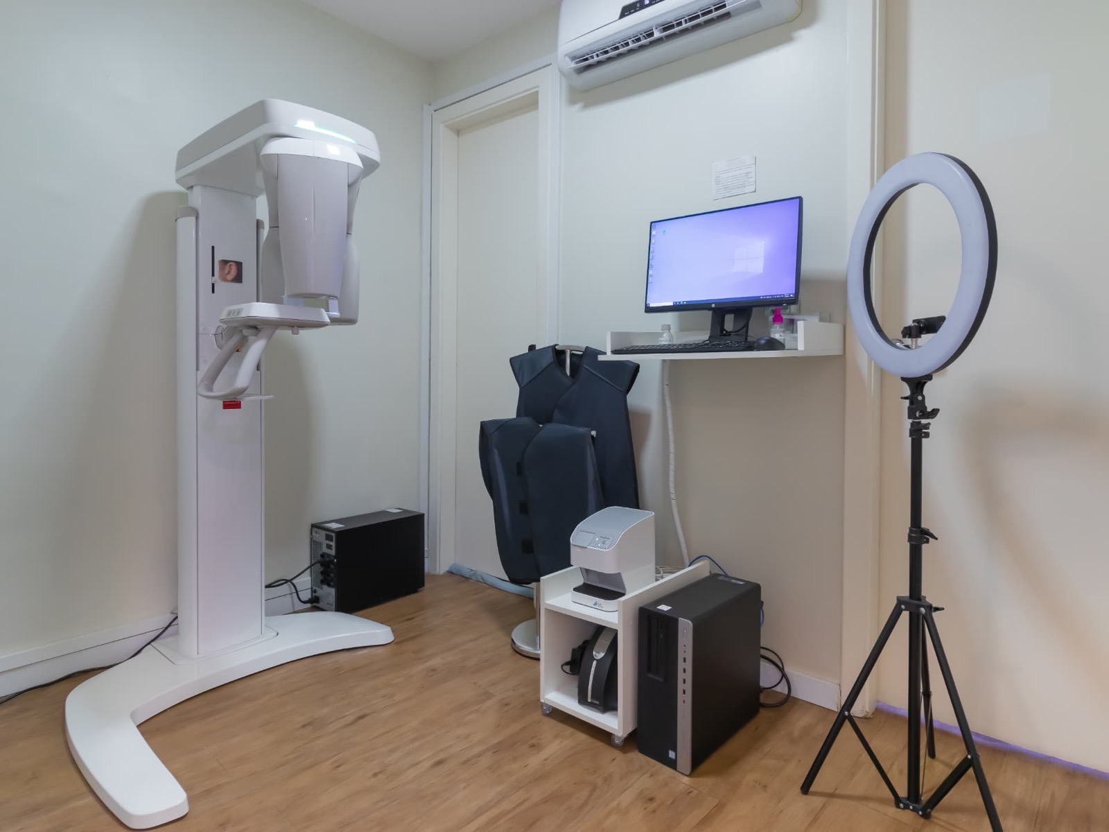 Sala de radiologia com aparelho de raio-x panorâmico e estação de imagem
